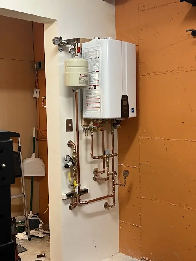 Plumbing technician inspecting water heater connections in San Gabriel